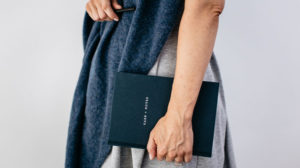 Image of a person wearing The Grace Files cashmere hug and holding our get well soon gift, The Grace Files Care + Notes journal