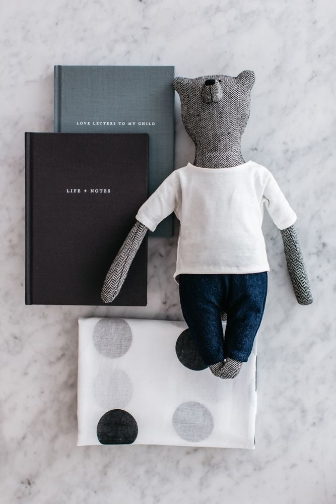 Photo of our Motherhood Kindness Kit featuring Life + Notes journal, Love Letters to My Child, muslin wrap and bear. A useful baby shower gift.