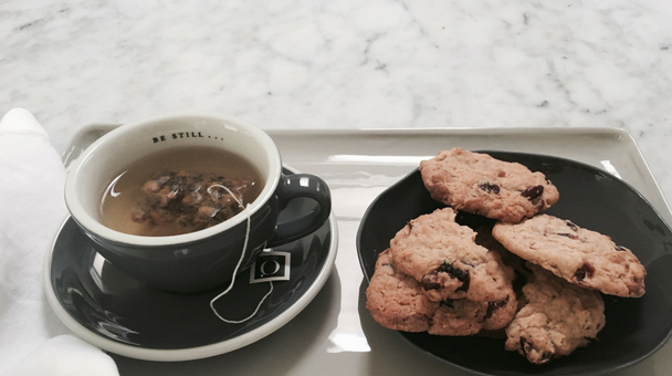 Image of a cup of tea and cookies on a tray.